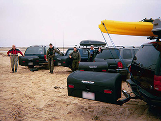 Group of surf fly fisherman with four vehicles, each with StowAway Standard Cargo Carrier swung out