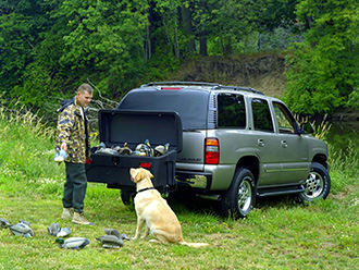 Duck hunter with his dog unloading decoys from StowAway Standard Cargo Carrier on Chevy SUV