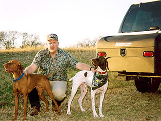 Two hunting dogs with their owner next to StowAway Standard Cargo Carrier