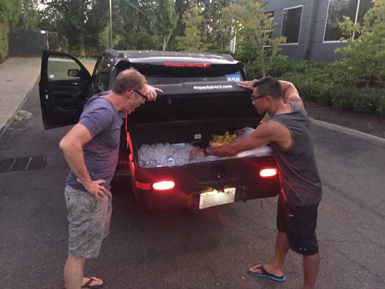 Two men standing in front of StowAway MAX Cargo Carrier full of ice