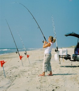 Woman fishing on beach with StowAway Surf Fishing Rod Rack