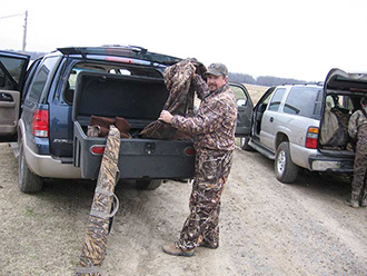 Duck hunter unloading gear from StowAway Standard Cargo Carrier on Ford Expedition