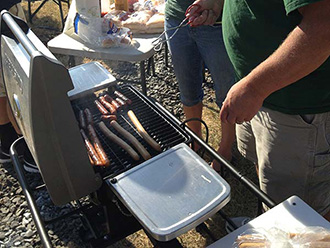 Oregon Ducks fans cooking hot dogs on a StowAway Hitch Grill Station