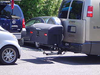 Close-up of travel van with dual-hitch towing package and StowAway Standard Cargo Carrier