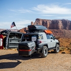 Toyota FJ Cruiser with American flag shown with rear door open and StowAway MAX Cargo Carrier swung out